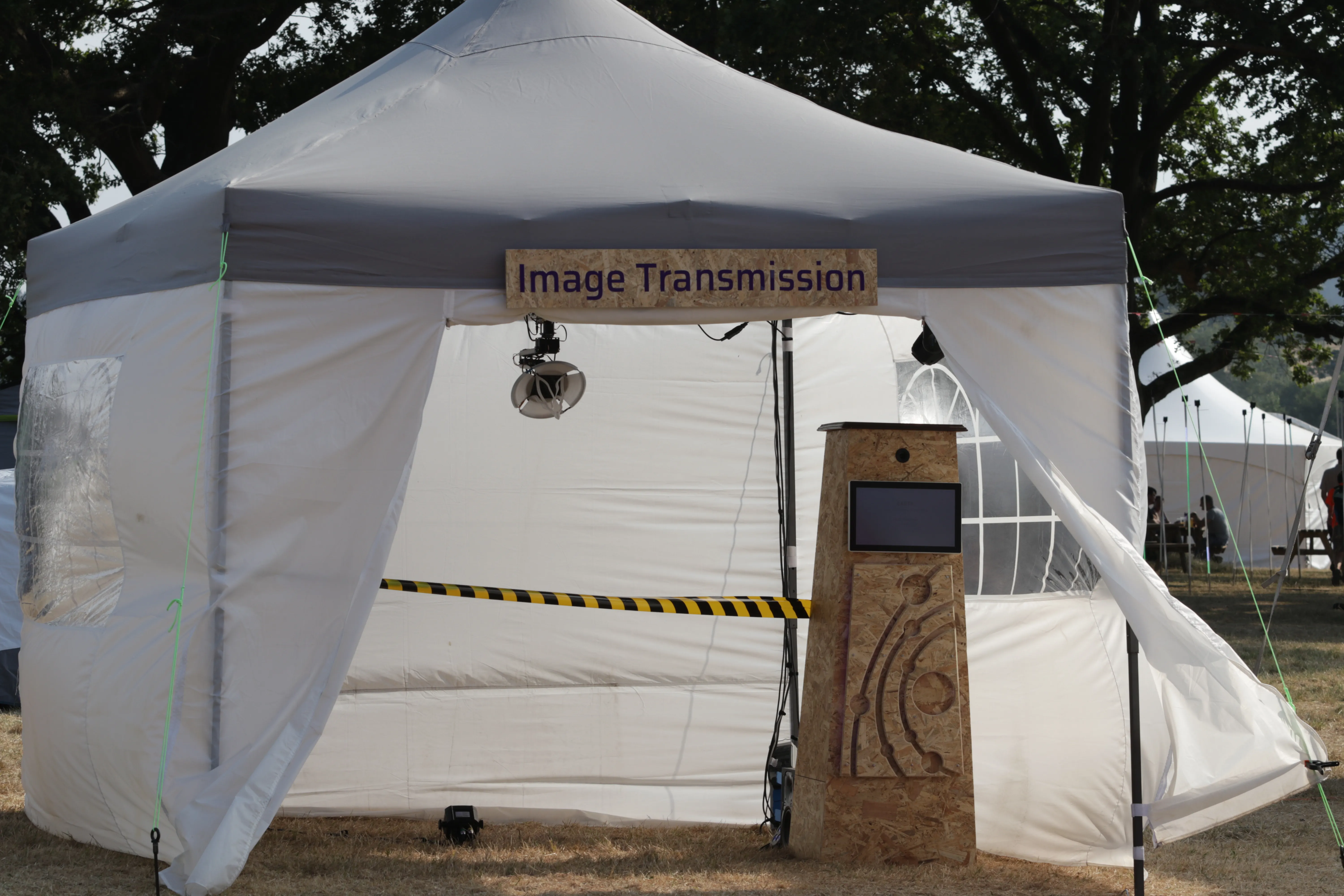 The installation in daylight: the gazebo and booth set up on the festival field.