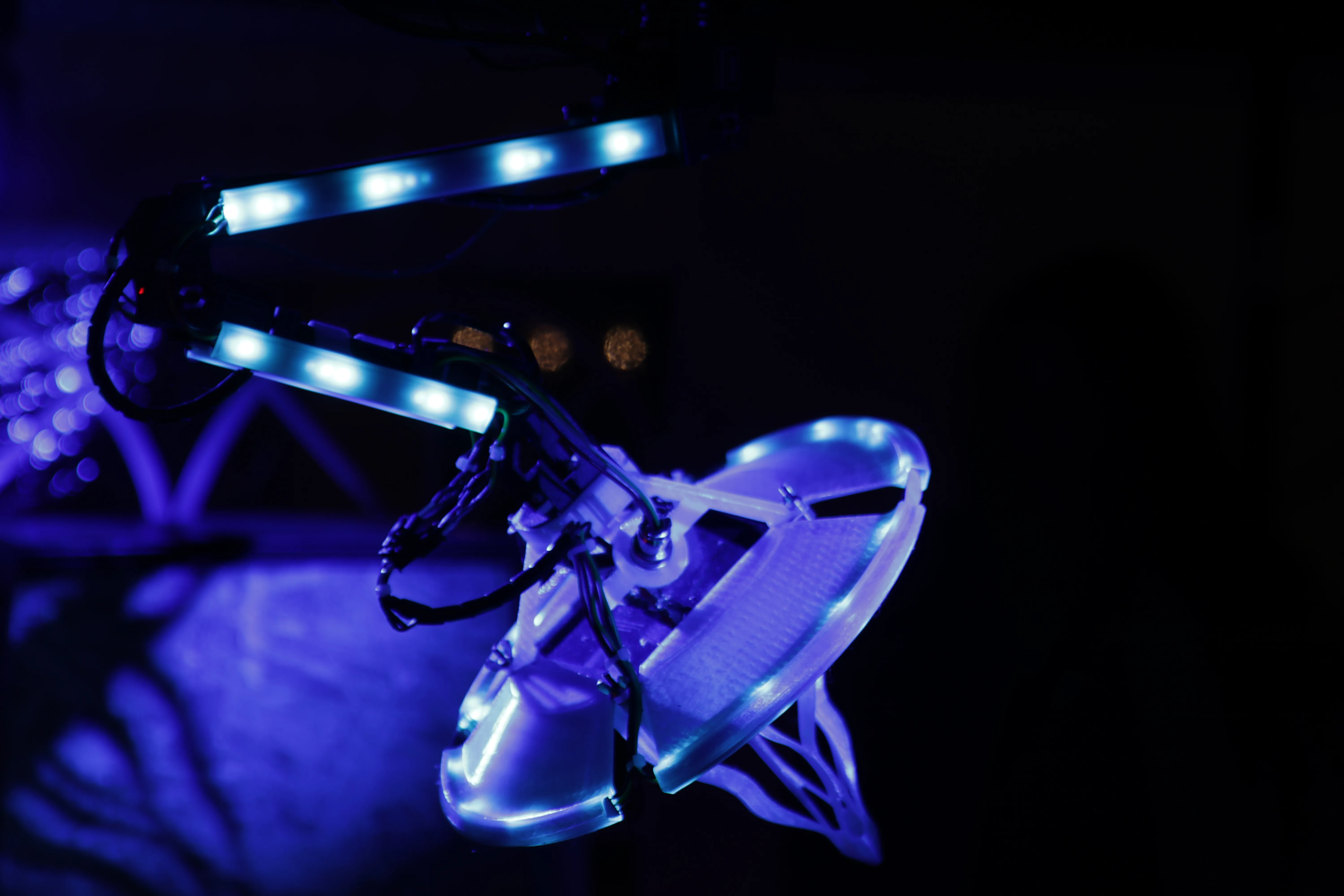 The arm and antenna at night, picked out in blue LED strip light against the dark interior of the gazebo.